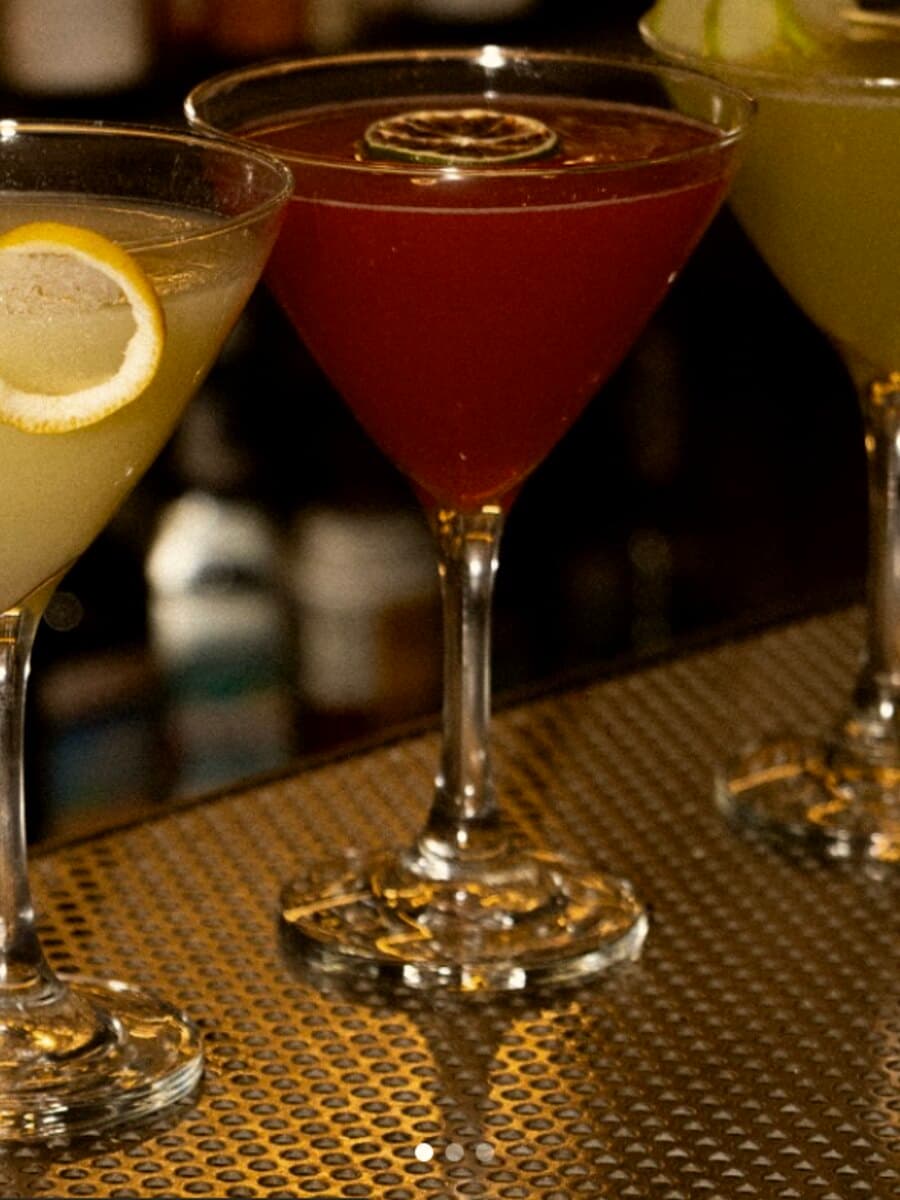 Three martinis lined up on the bar at Killer Queens Social House
